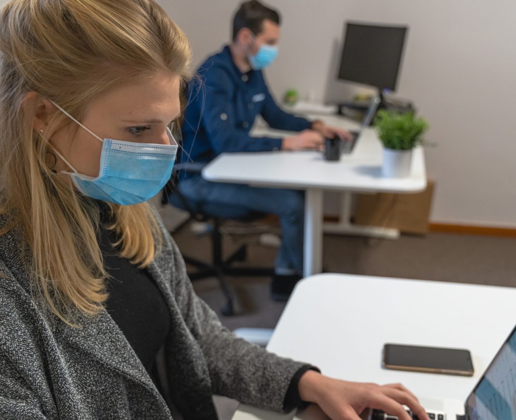 Office workers with masks at their work computers