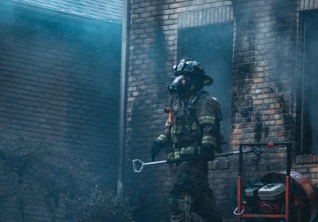 EIO_WP_Arson_02-2021_Page_1_Image_0001 Firefighter exiting a burned building