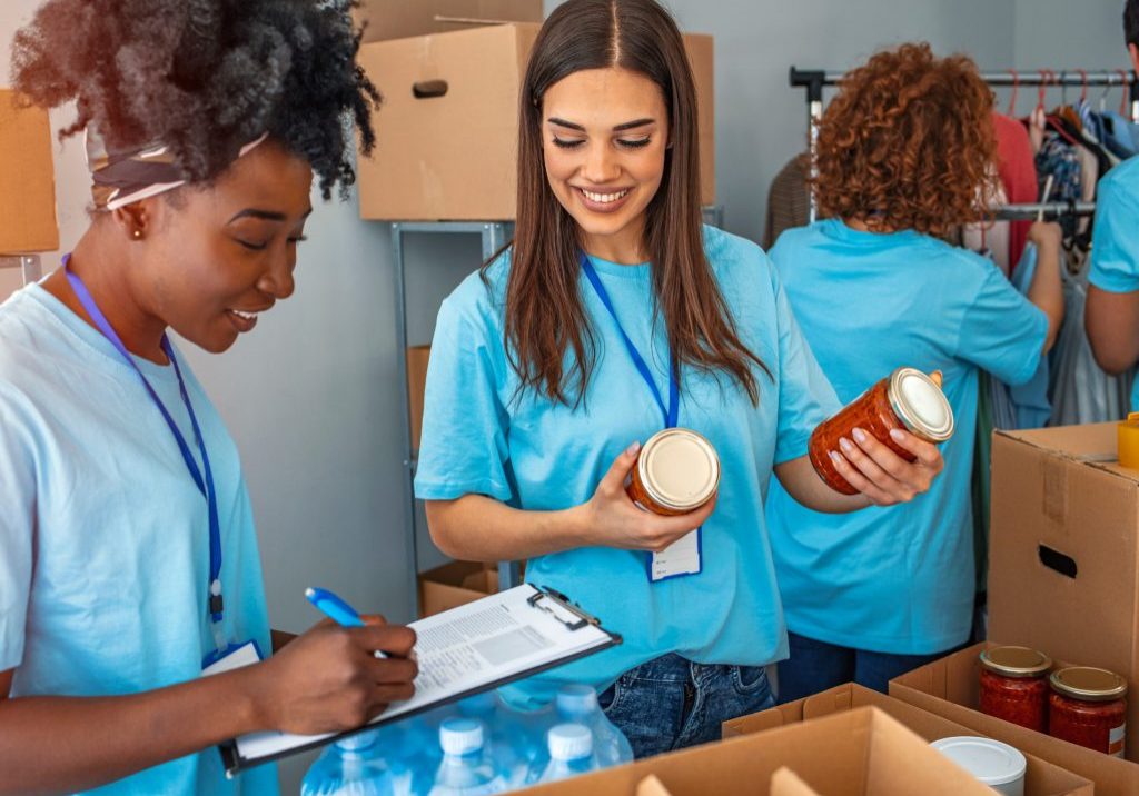EIO_WP_VolunteerManagement_02-2021_Page_1_Image_0001 Volunteers sorting canned goods with a clipboard