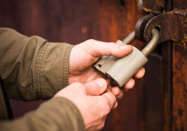 Close up angle of someone securing a lock on a wooden door