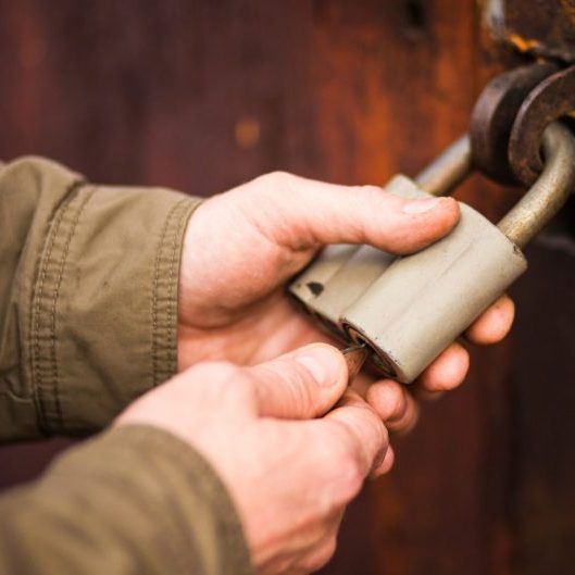 Close up angle of someone securing a lock on a wooden door