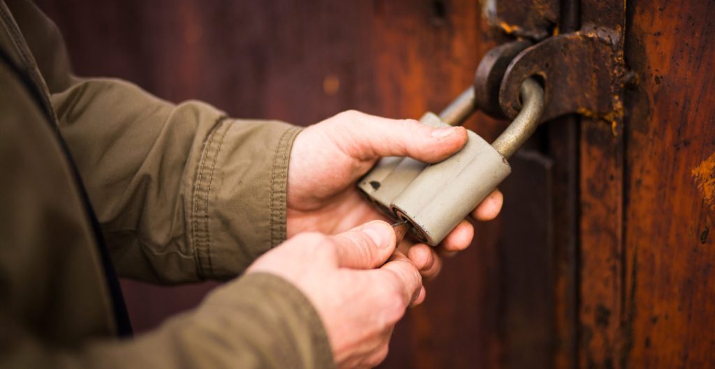 Close up angle of someone securing a lock on a wooden door