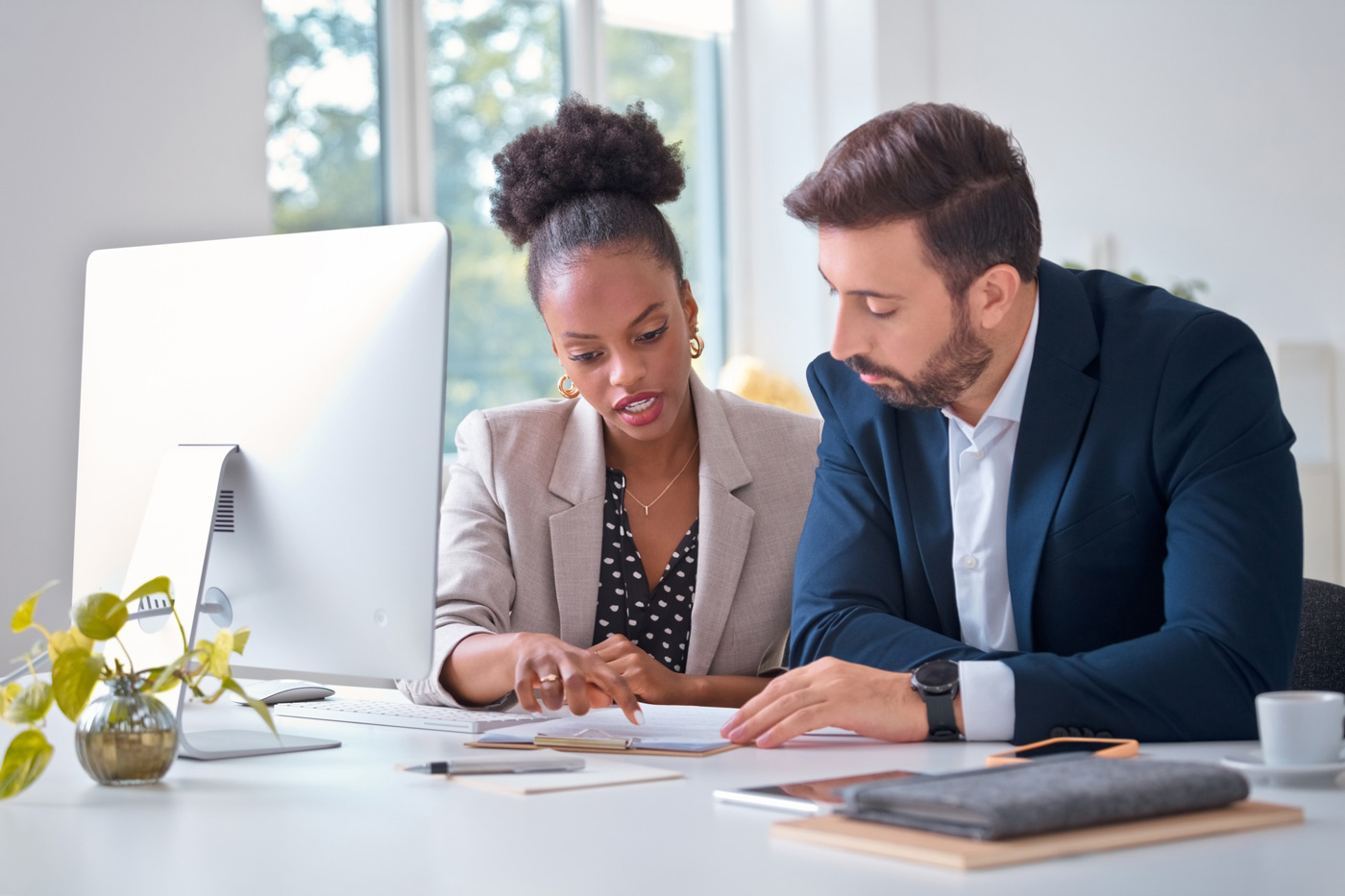 vas-intro Two employees at a desk look over some notes