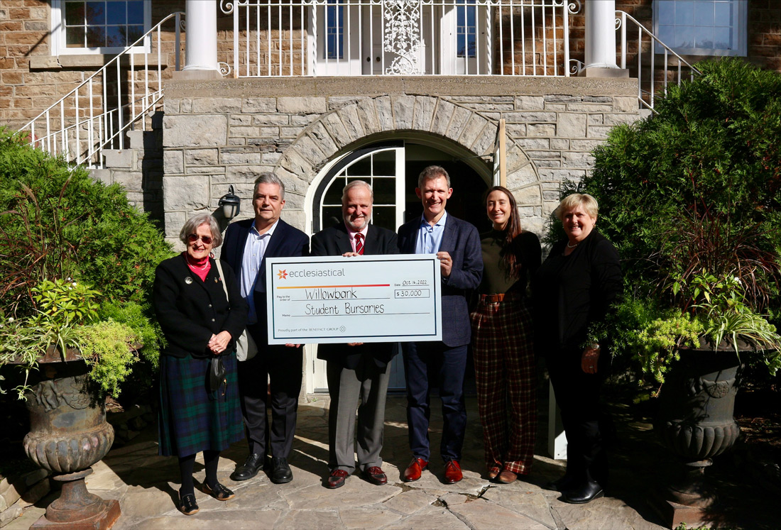 Group of Ecclesiastical employees hold a large cheque out front of Willowbank